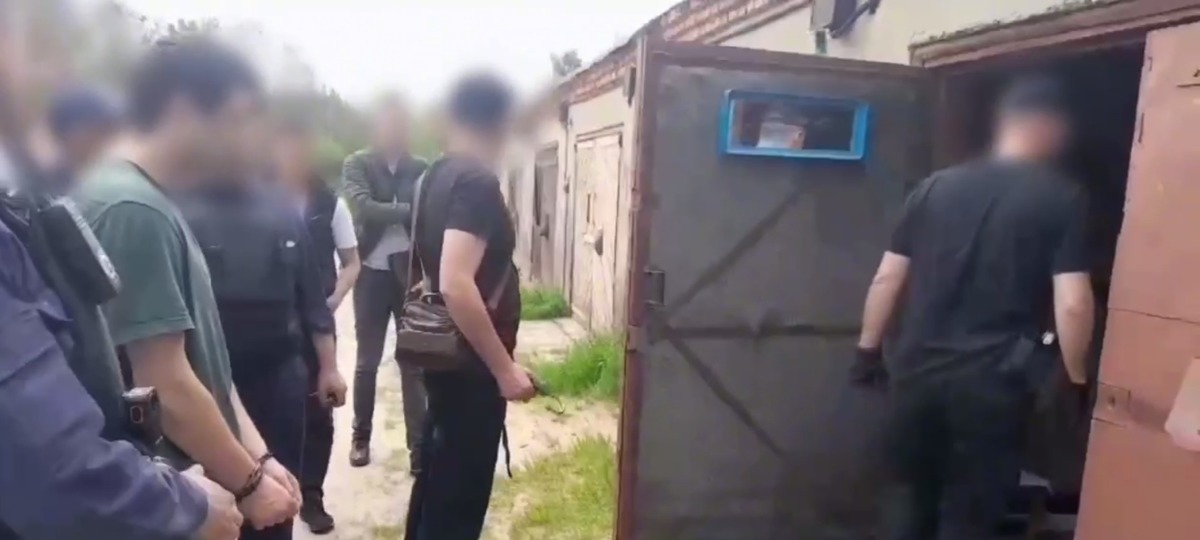 Один из задержанных жителей Брестчины в наручниках в окружении силовиков. Скриншот видео УВД Гродненского облисполкома