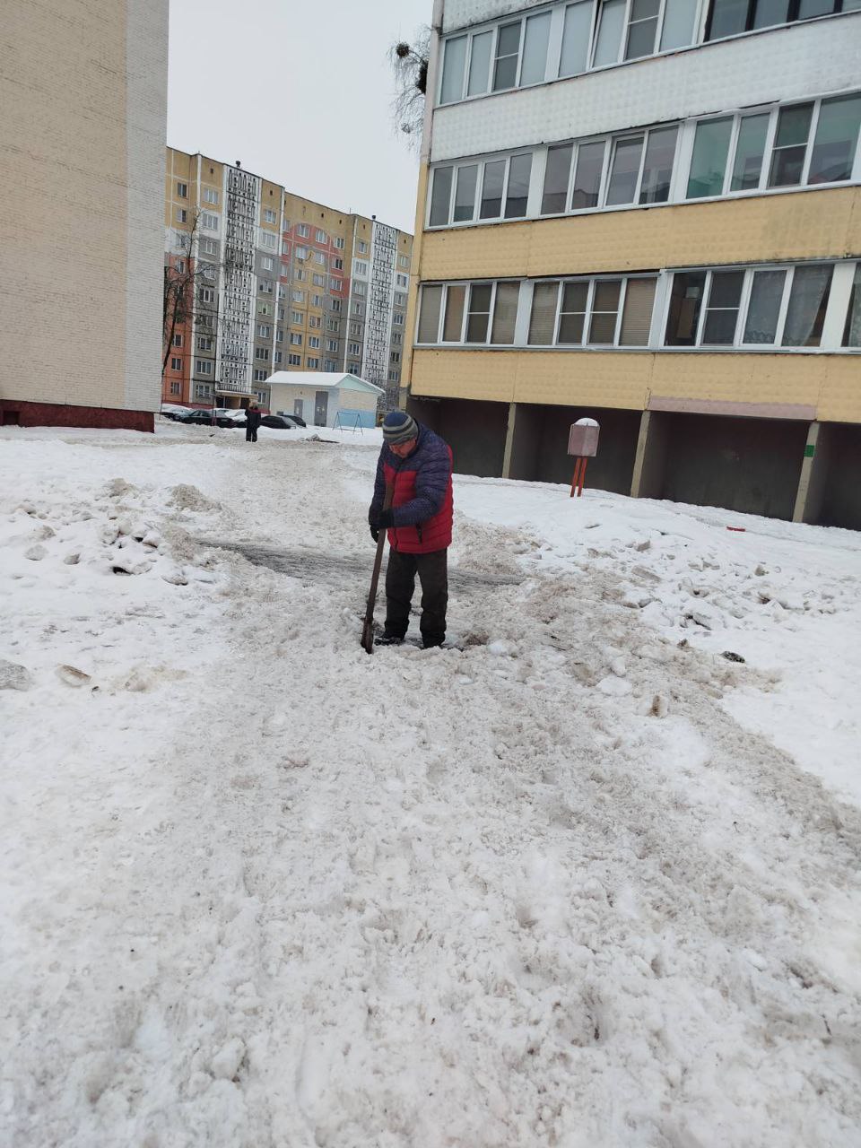 Дворник убирает снег в одном из дворов Речицы.