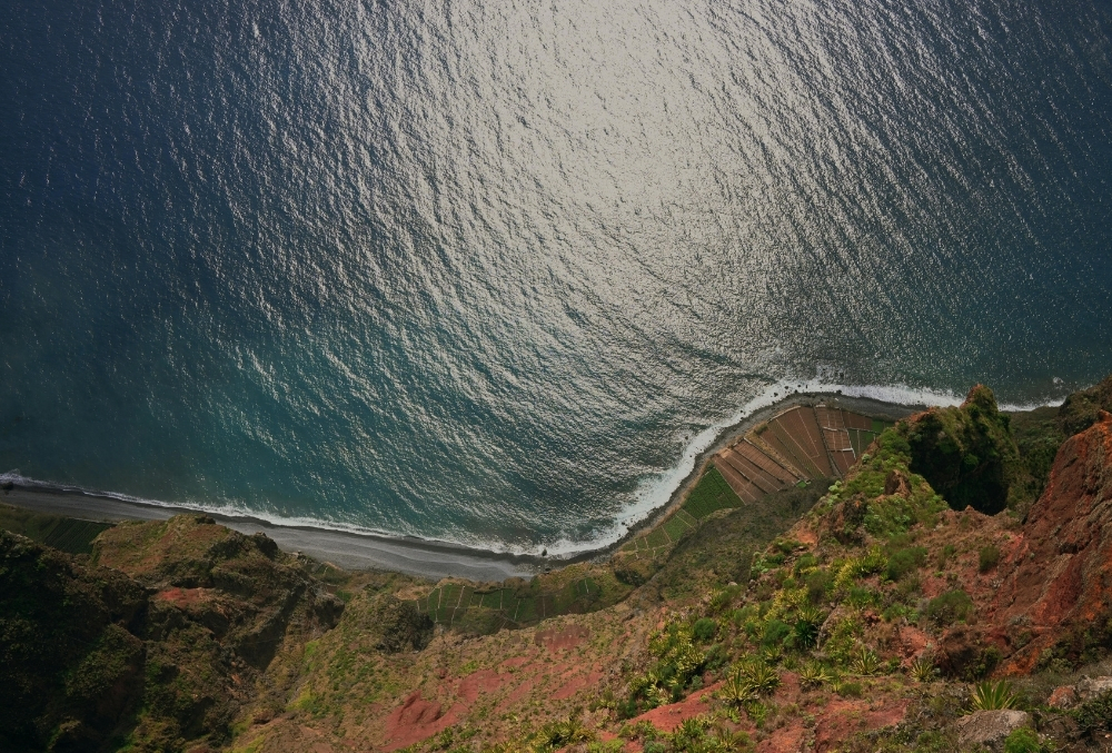 Вид с высокого утеса на Атлантический океан и узкую береговую линию внизу — дикий пейзаж Мадейры